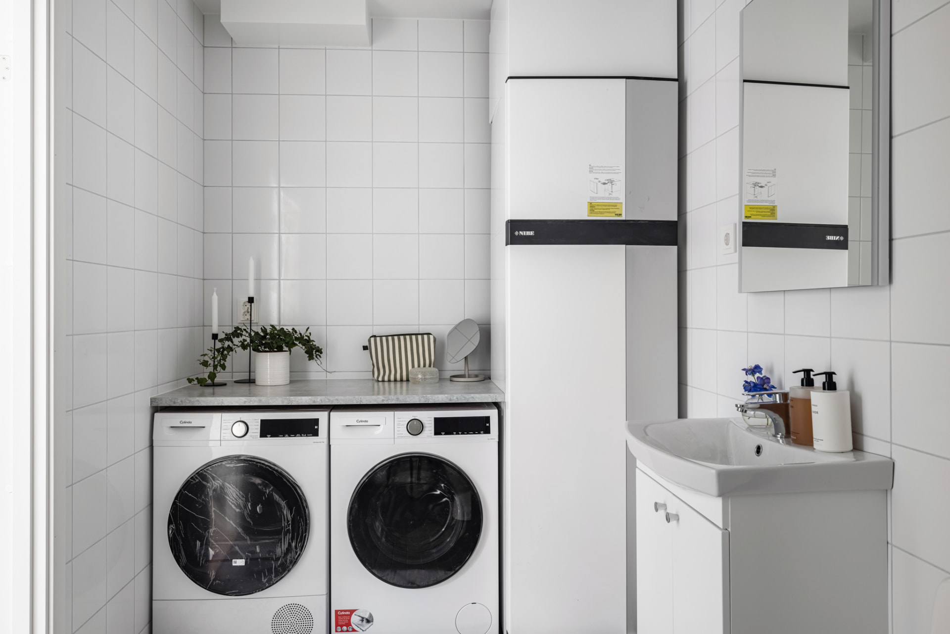 Praktisk tvättplats med tvättmaskin, torktumlare och arbetsbänk.