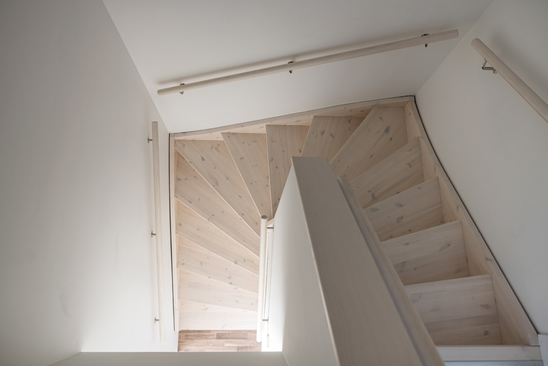 Trappan i vitlaserat trä förbinder bostadens två plan.